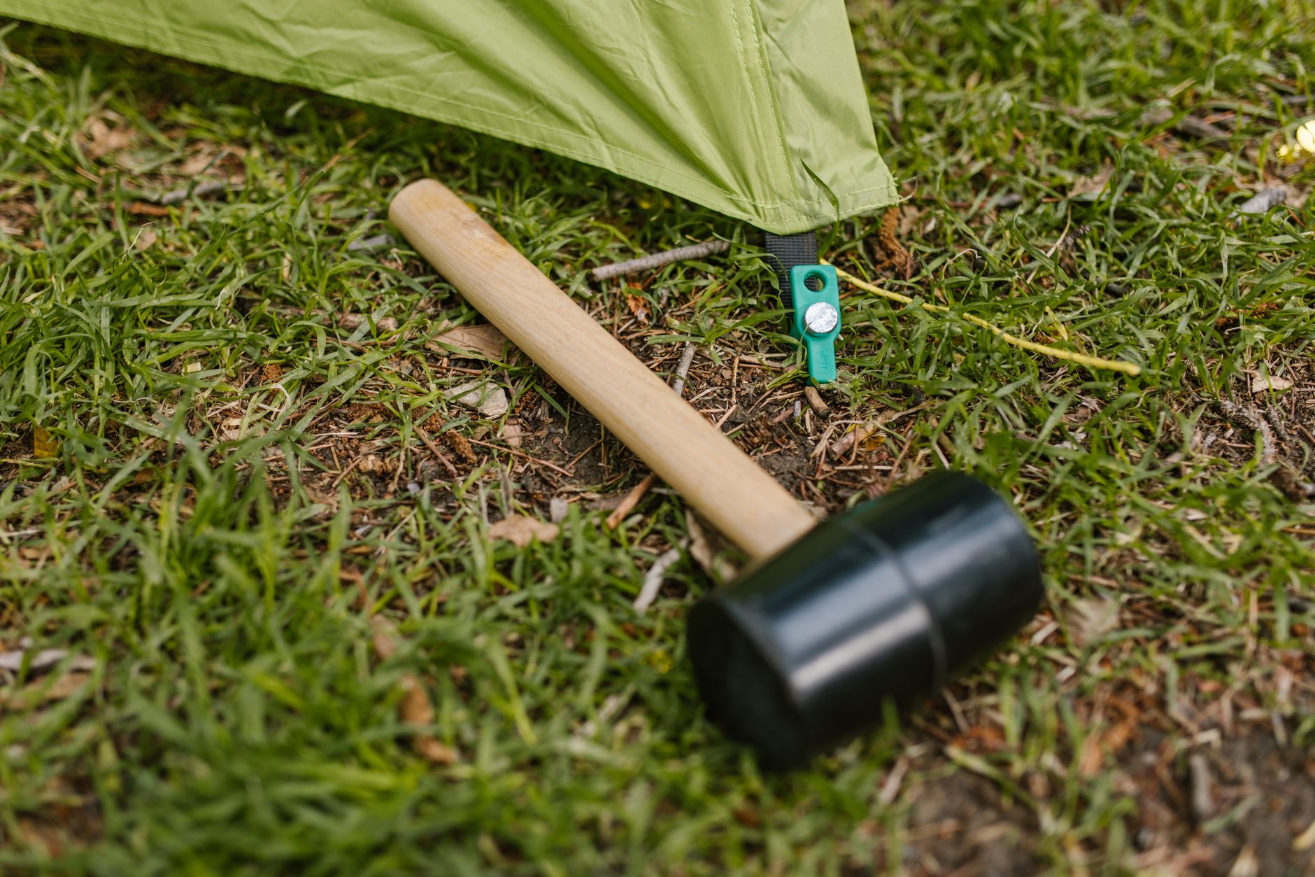 Hiker checking tent pegs in soft ground as part of a wild camping checklist